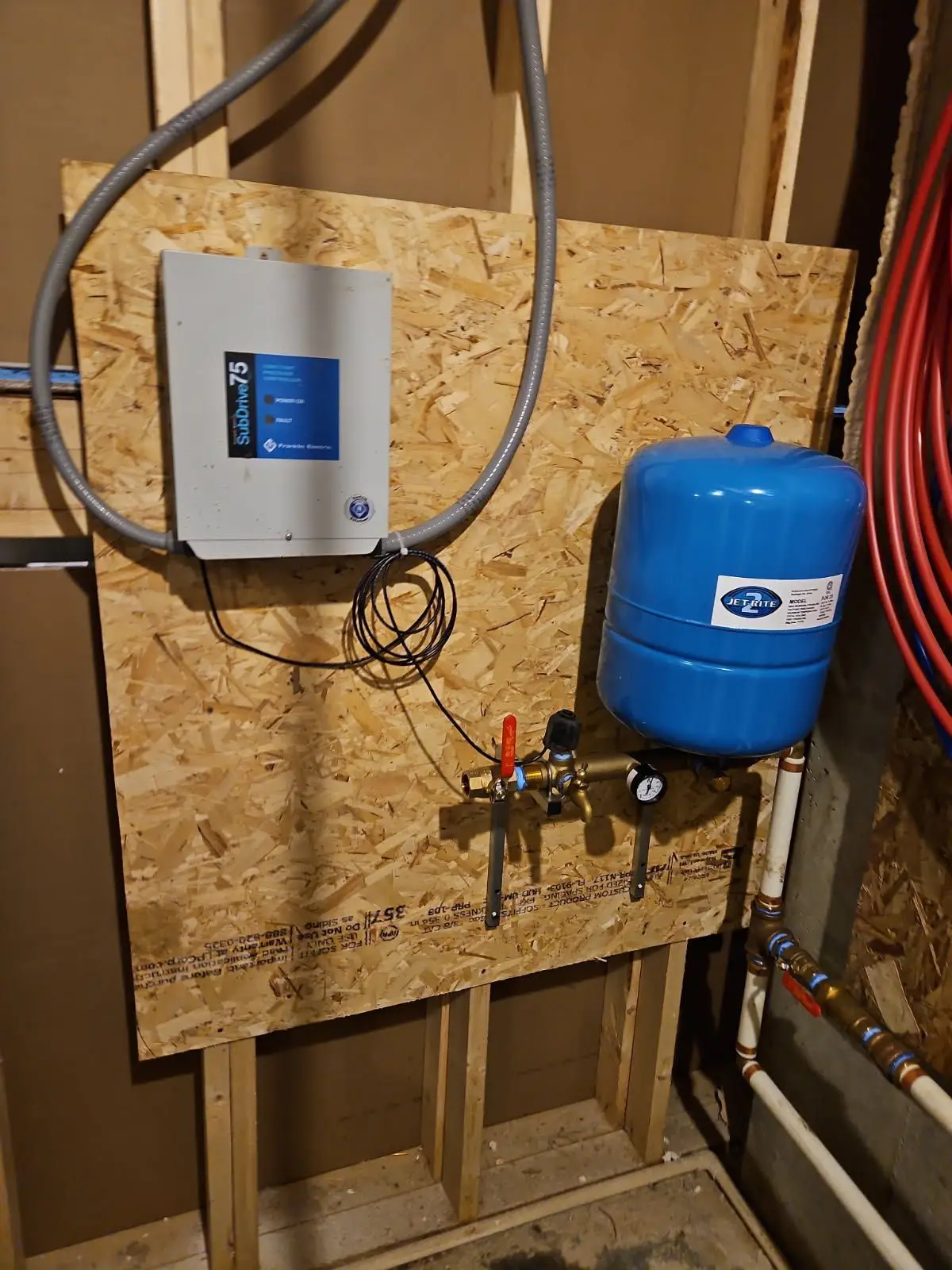 A technician measuring a water pump during a constant pressure system installation
