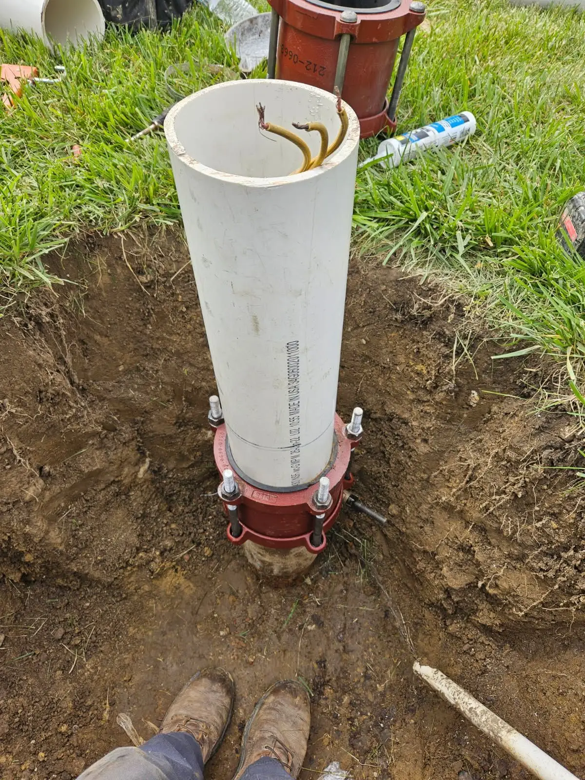 A technician repairing a well pipe in an open trench