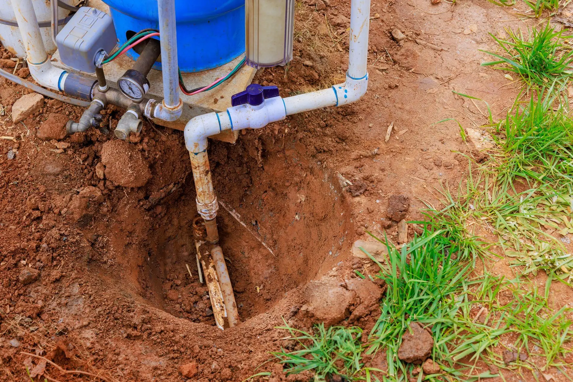 A water well pump being installed in an excavated pit