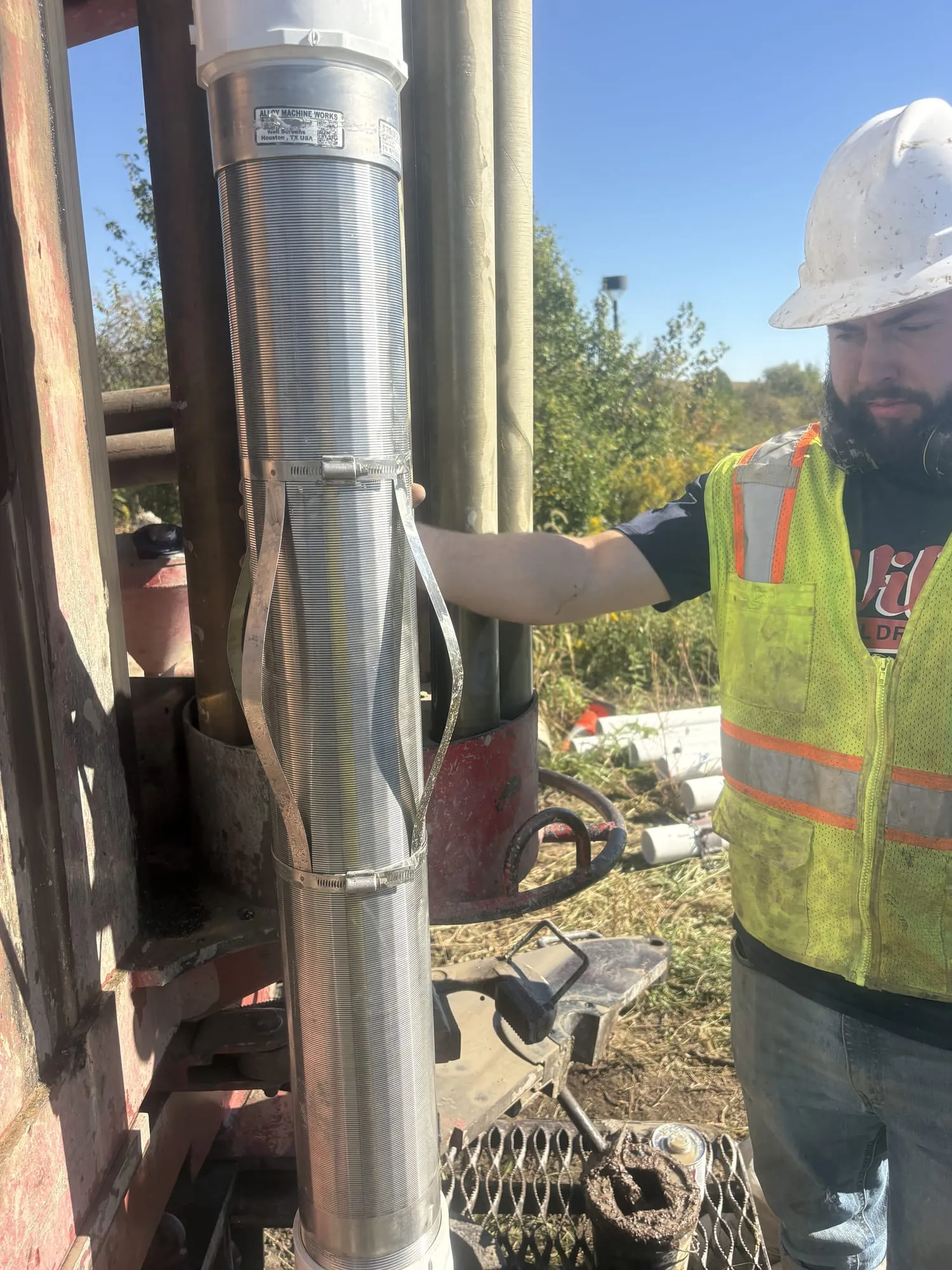 Wiley Well Drilling crew guiding well casing into a drilled hole