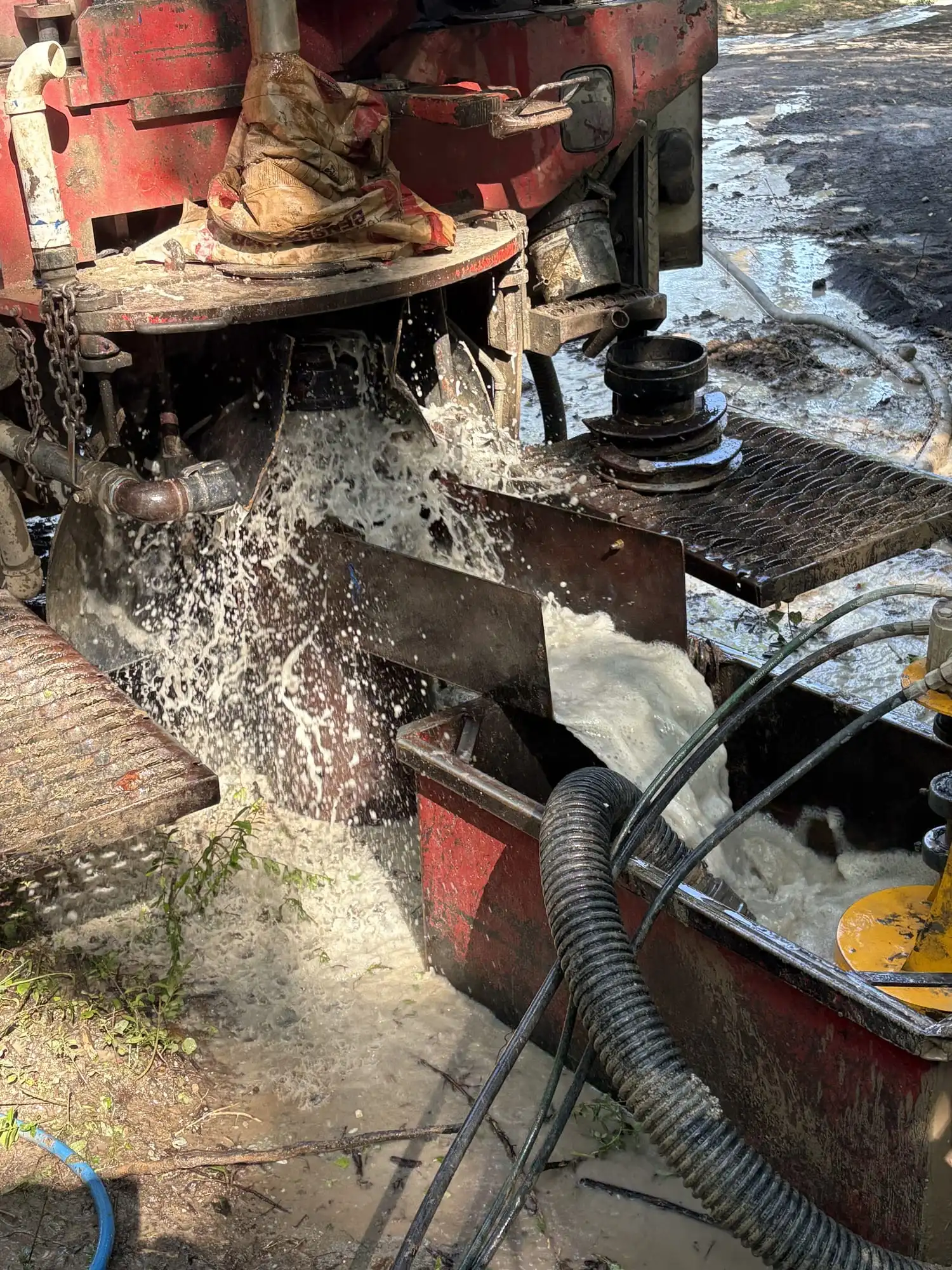 Water and drill cuttings spraying across the rig table while a well is drilled