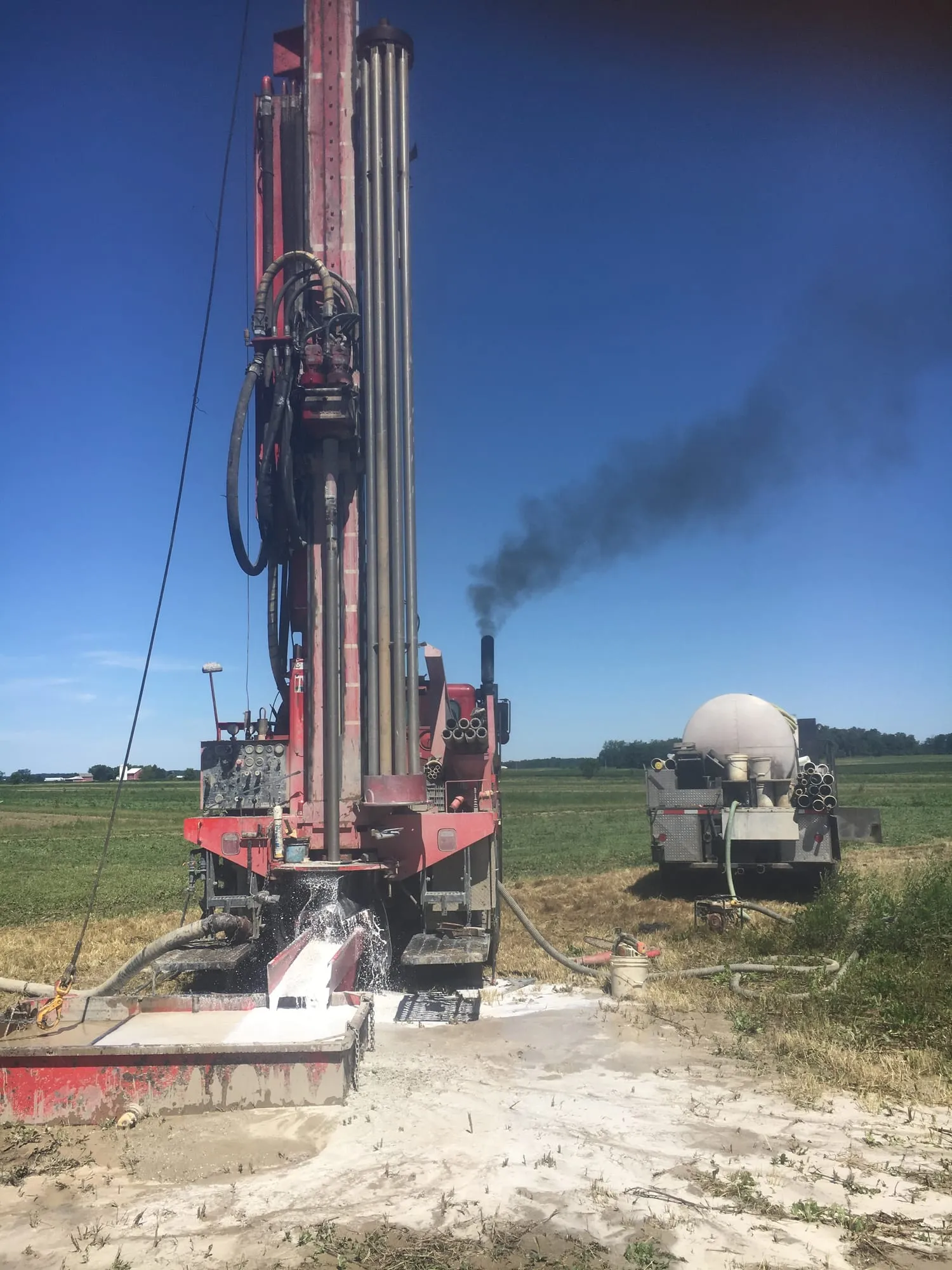 Wiley Well Drilling rig set up and drilling in an open farm field