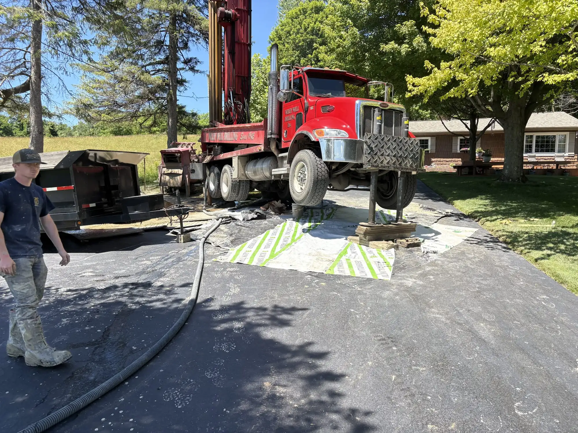 Wiley Well Drilling rig truck set up on a job site with a crew member nearby