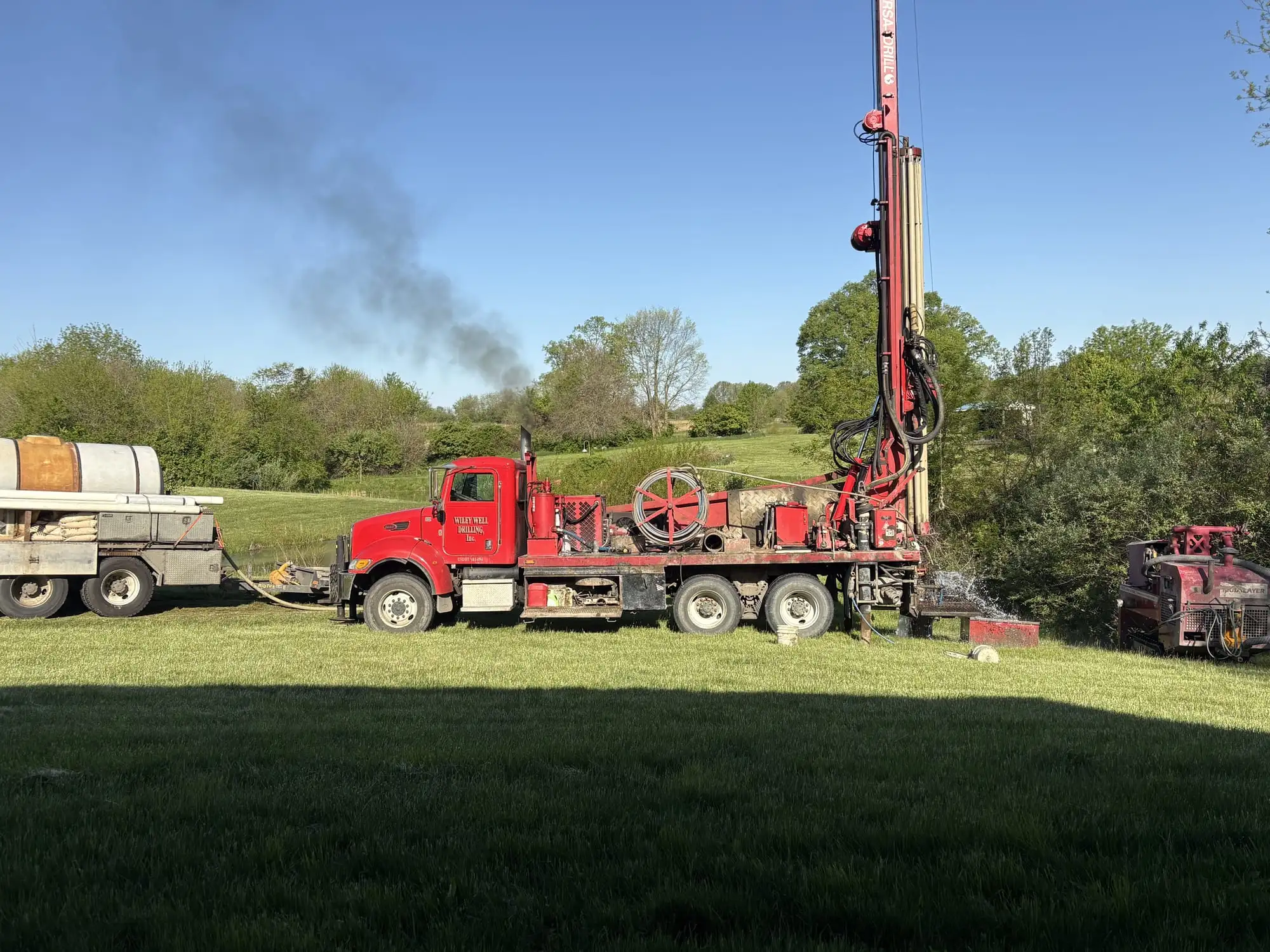 A Wiley Well Drilling rig truck set up on a well site in an open field